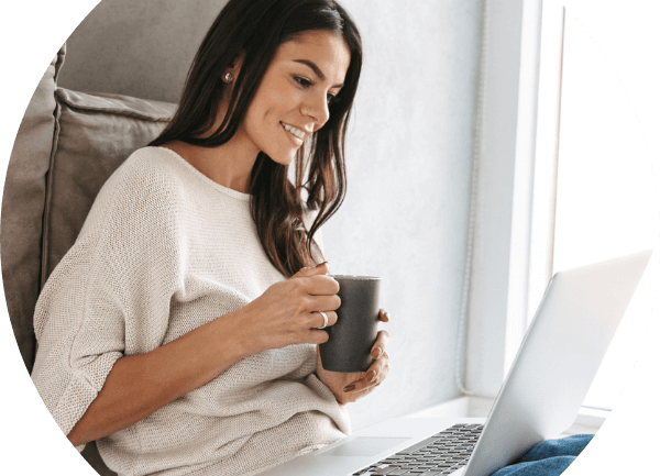 Frau schaut mit Lächeln im Gesicht und interessiert auf ein Laptop