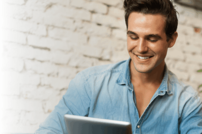 Junger Mann schaut auf Tablet