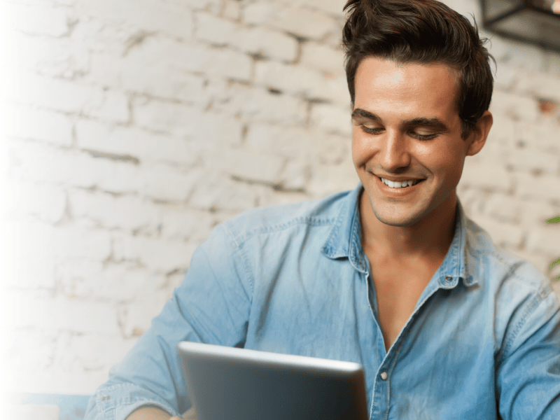 Junger Mann schaut auf Tablet