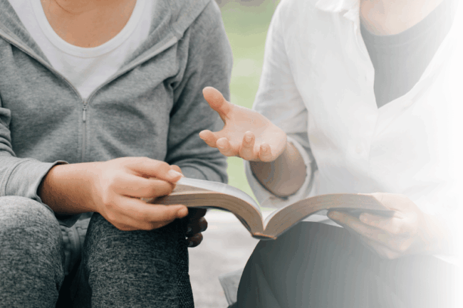 Zwei Personen lesen ein Buch
