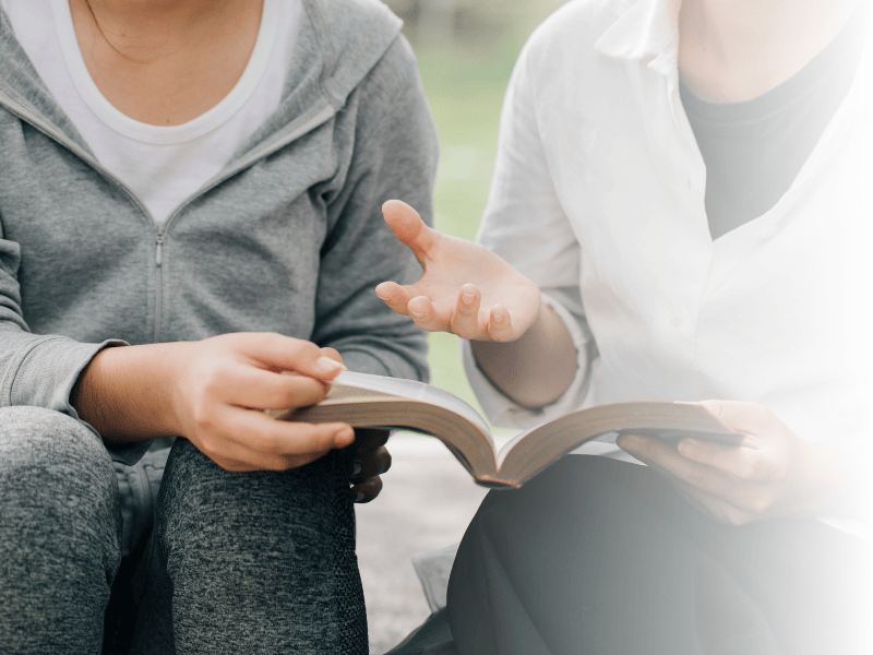 Zwei Personen lesen ein Buch
