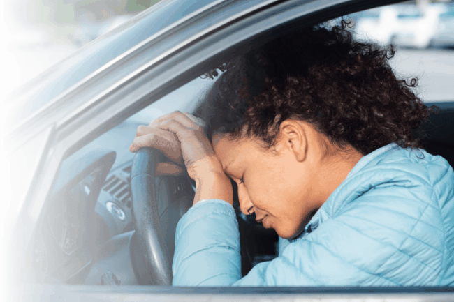 Frau lehnt sich traurig auf Lenkrad
