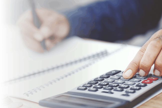 Mann mit Taschenrechner am Tisch