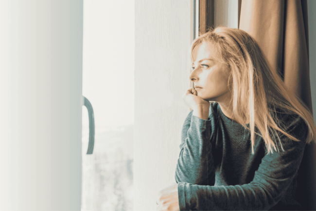 Nachdenkliche Frau schaut aus dem Fenster