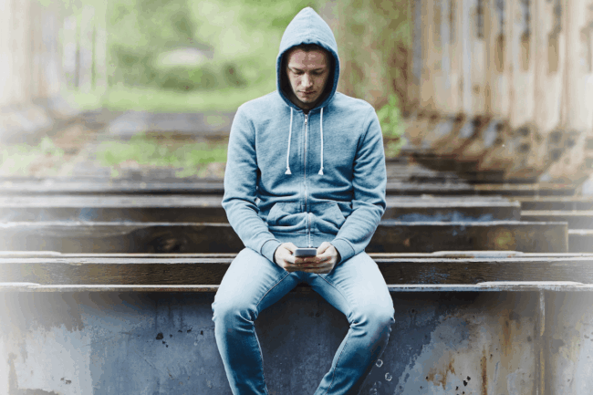 Einsamer Mann schaut auf Handy