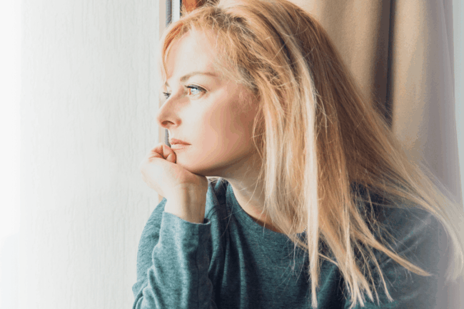 Frau schaut aus dem Fenster